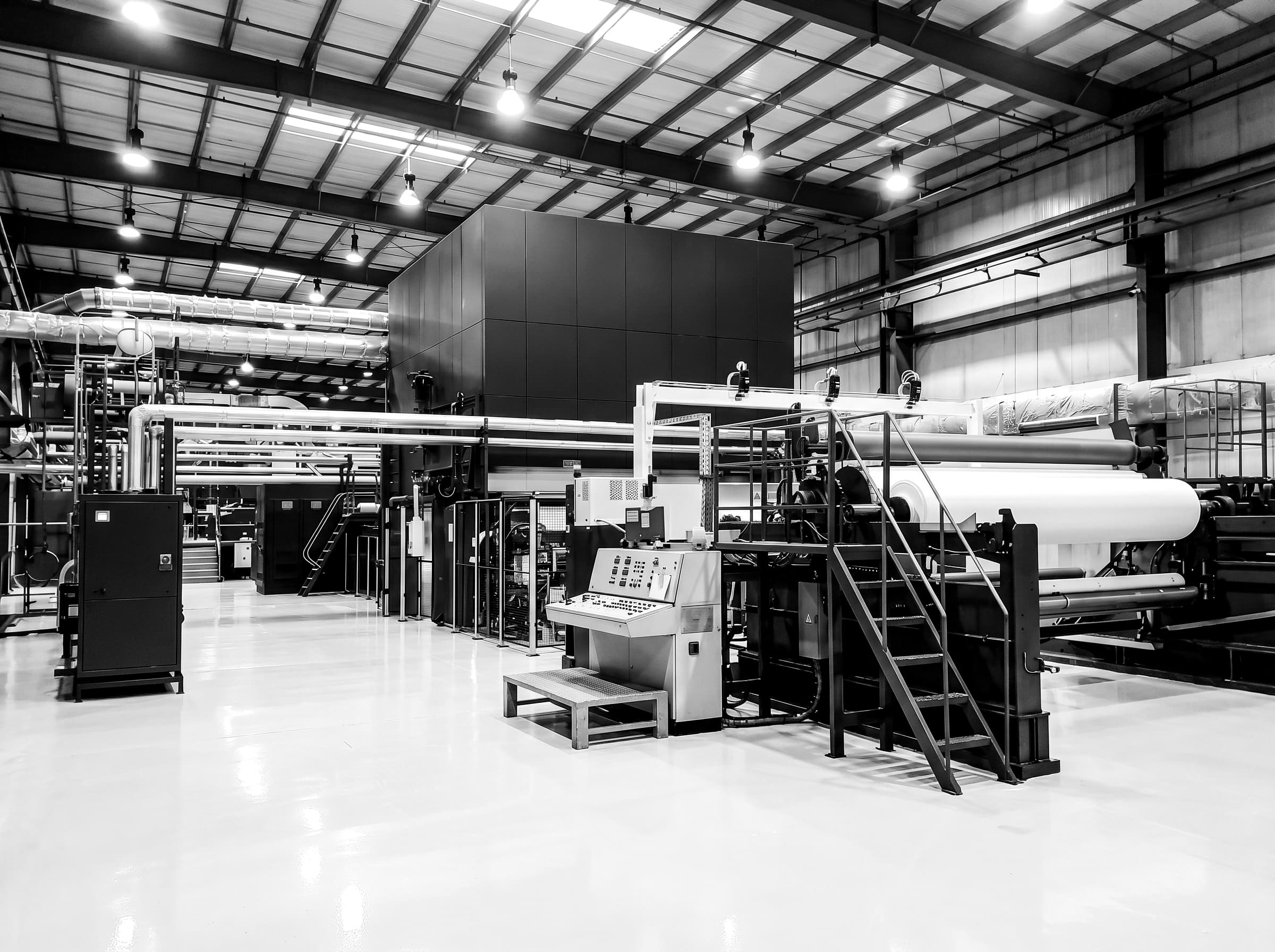 Industrial nonwoven production line with rollers and fiber web in a clean facility